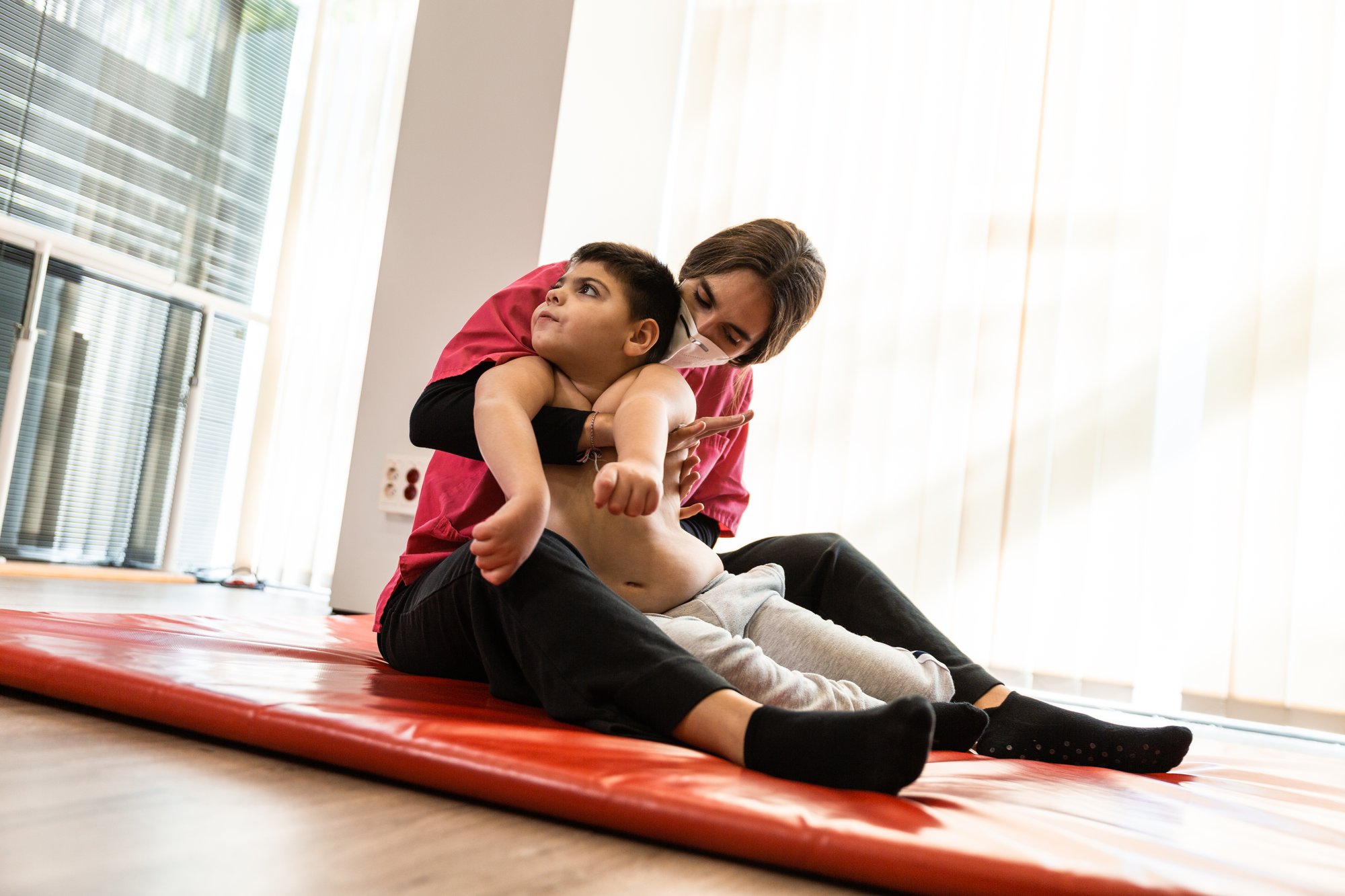 disabled-child-and-physiotherapist-on-a-red-gymnas-2025-01-09-05-11-02-utc
