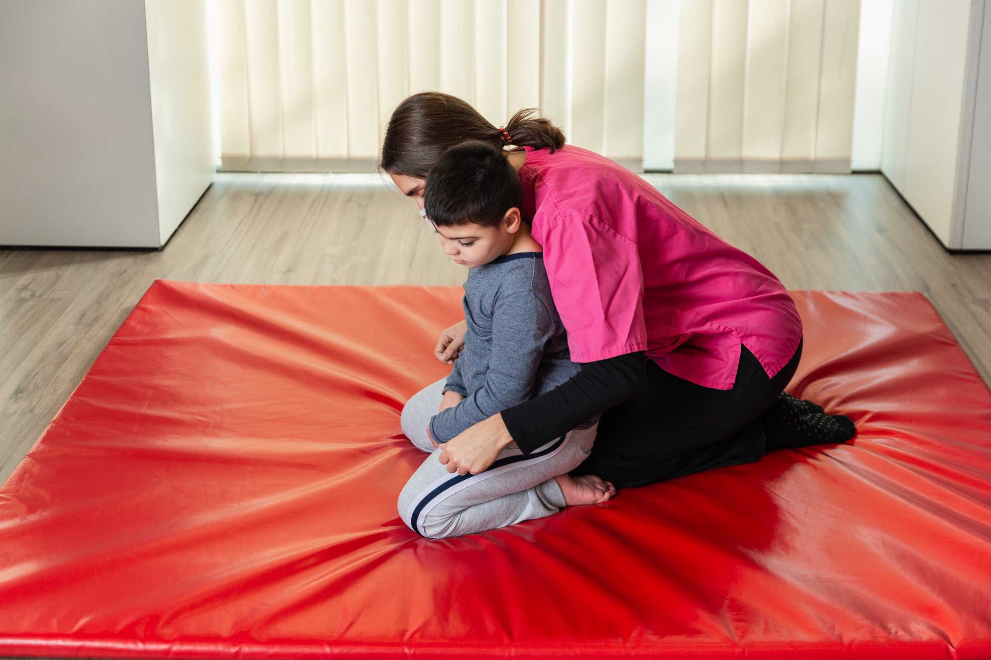 disabled-child-and-physiotherapist-on-a-red-gymnas-2025-01-09-07-44-16-utc